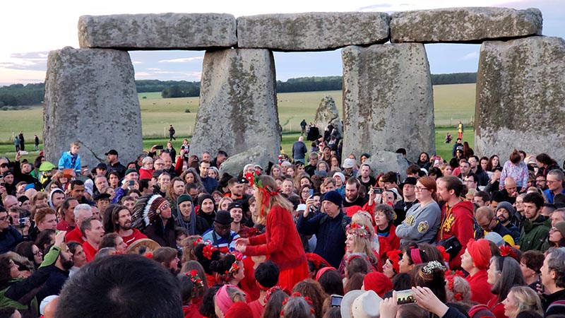grupo cantando no centro de stonehenge