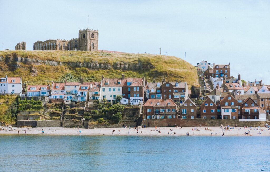 Whitby é uma das cidades na Inglaterra com litoral encantador, casas coloridas e uma abadia histórica no topo da colina.