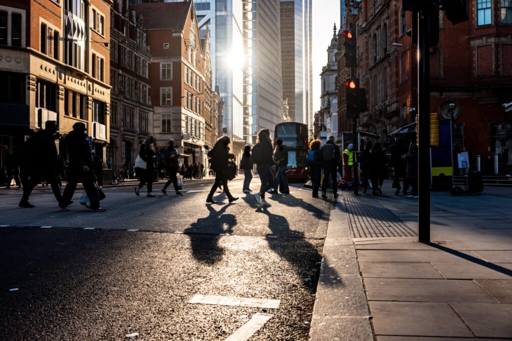 Pessoas atravessando rua movimentada em Londres, representando dicas de etiqueta para não fazer feio com os ingleses