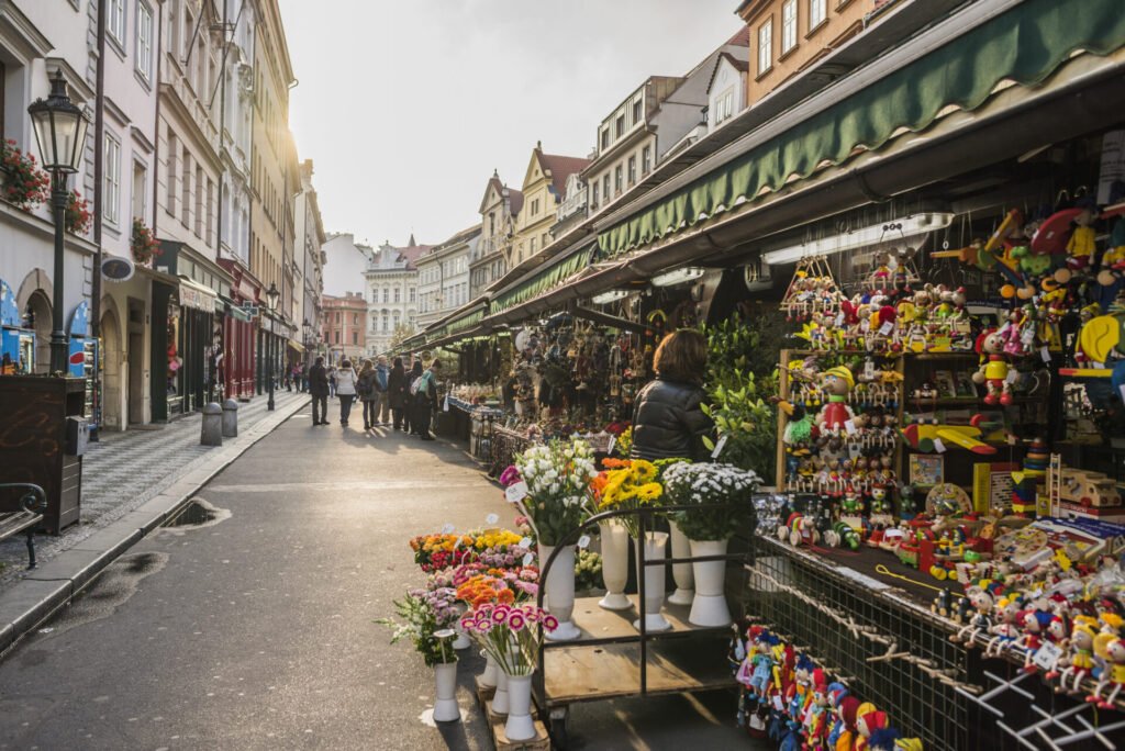 Mercado de Havel em Praga com barracas coloridas e produtos locais, exemplo de atividade autêntica para um roteiro slow travel