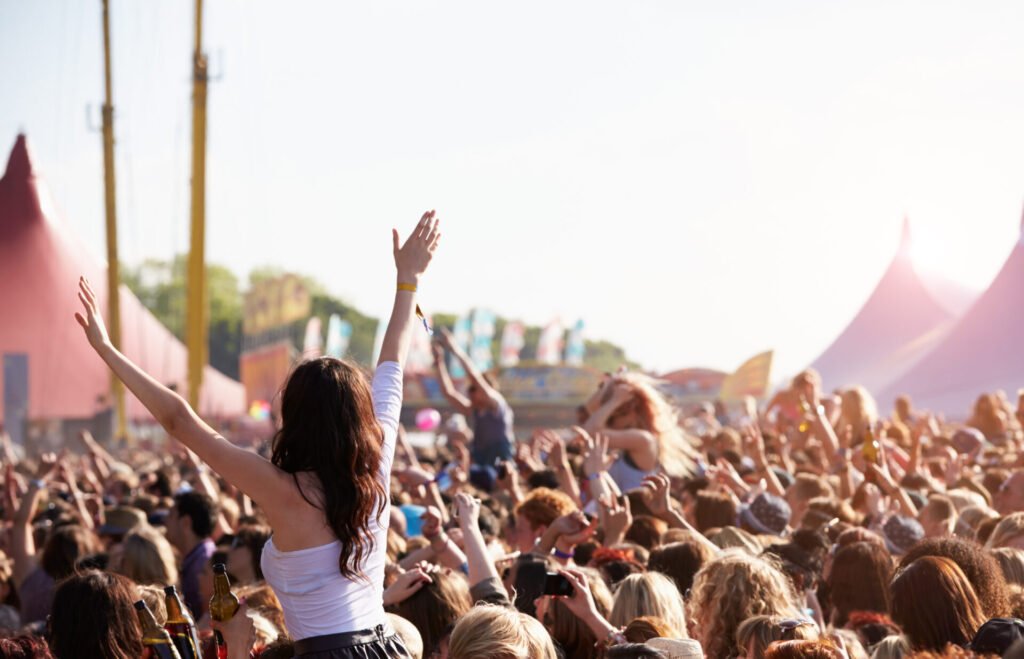 Público em festival de música ao ar livre durante o dia, com tendas ao fundo; referência para roupas e clima europeu no guia de Festivais de música na Europa