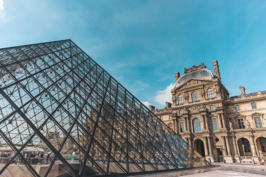 Vista da Pirâmide de Vidro e do edifício histórico do Museu do Louvre em Paris