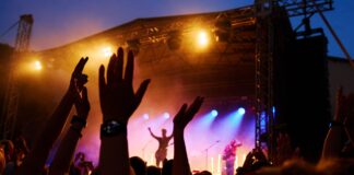 Festivais de música na Europa: quais são os principais? Festivais de música na Europa com multidão em frente ao palco iluminado ao anoitecer